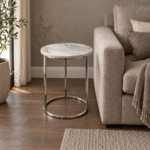 SS base with stone top end table beside a sofa in a contemporary living room