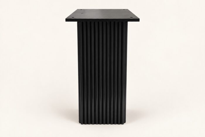 Black wooden carved base end table on warm ivory background