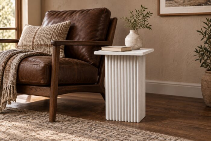 White wooden carved end table beside a leather lounge chair in a contemporary living room