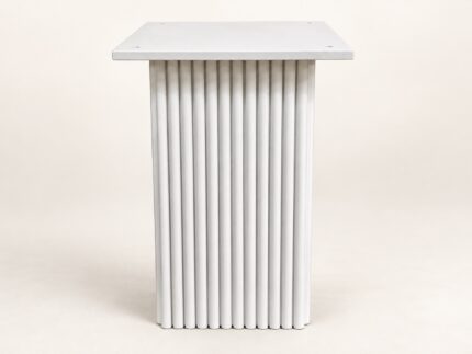 White wooden carved base end table on warm ivory background