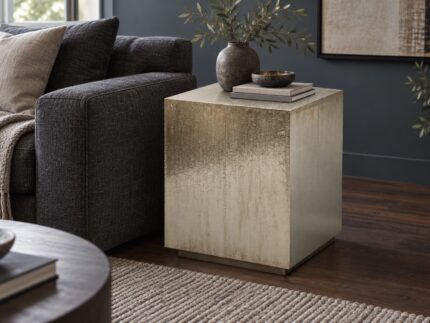 Hammered metal cladded end table beside a charcoal sofa in a contemporary living room