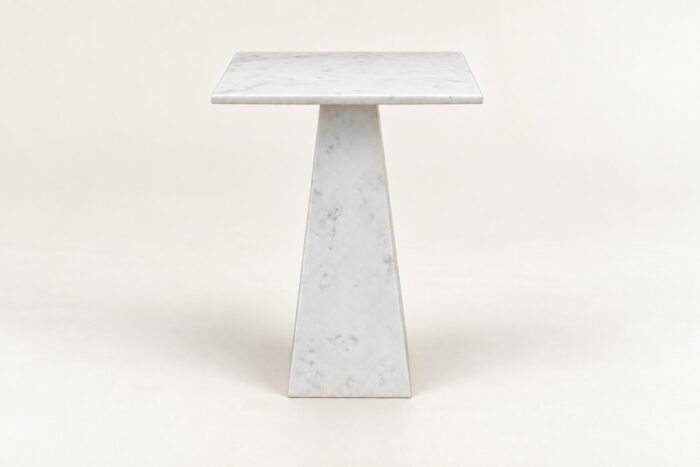 White stone end table on warm ivory background