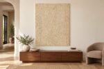 Bone inlay on plywood panel displayed above a wooden cabinet in a warm living room