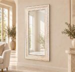 Venetian glass mirror frame with an ivory mosaic-style border in a warm villa interior