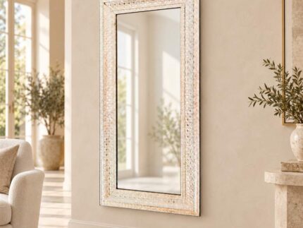 Venetian glass mirror frame with an ivory mosaic-style border in a warm villa interior