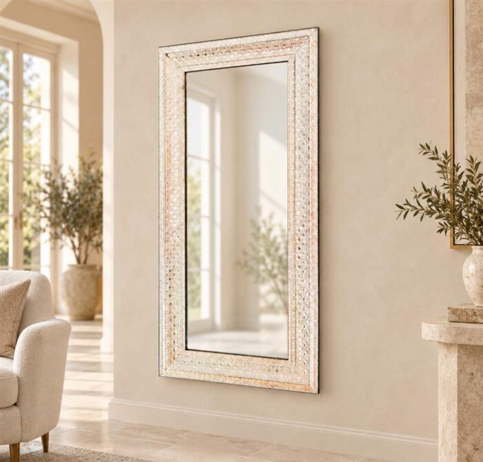 Venetian glass mirror frame with an ivory mosaic-style border in a warm villa interior